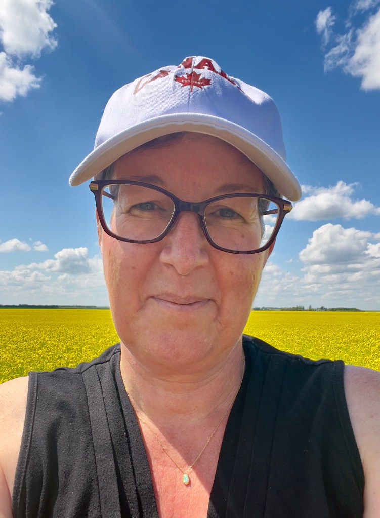 Kimberly Hall, blue sky and a canola field in Saskatchewan