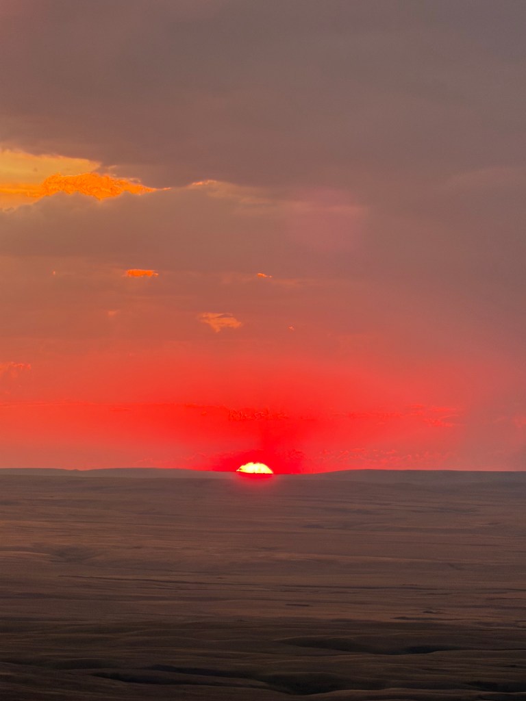 sun disappearing on the horizon Bald Butte, Cypress Hills, Saskatchewan